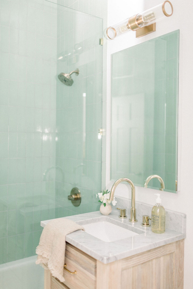 Small transitional green tile and ceramic tile porcelain tile and white floor bathroom photo in New York with shaker cabinets, light wood cabinets, a one-piece toilet, white walls, an undermount sink, marble countertops and white countertops