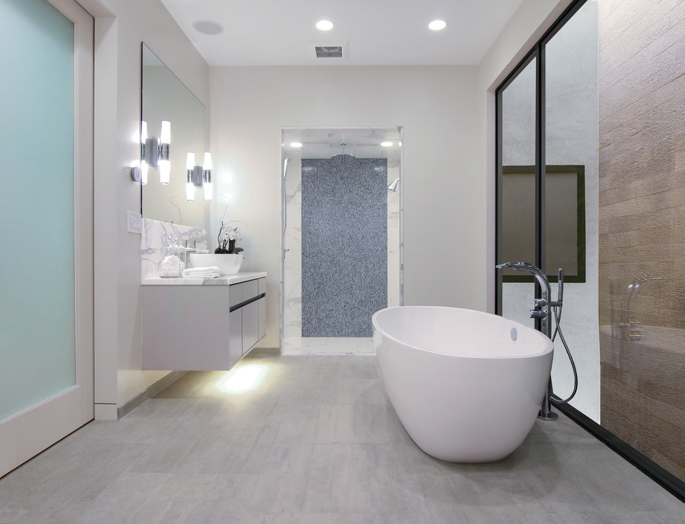 Idée de décoration pour une salle de bain principale minimaliste avec une vasque, un placard à porte plane, des portes de placard grises, un plan de toilette en marbre, une baignoire indépendante, une douche ouverte, un carrelage blanc et des dalles de pierre.