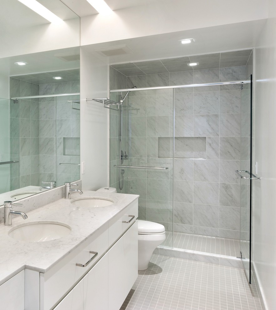 Источник вдохновения для домашнего уюта: ванная комната в современном стиле с врезной раковиной, плоскими фасадами, белыми фасадами, душем в нише, серой плиткой, белыми стенами и полом из мозаичной плитки