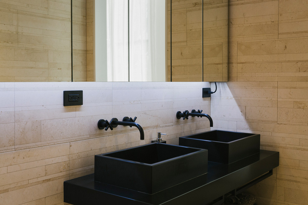 Imagen de cuarto de baño principal actual con bañera exenta, baldosas y/o azulejos beige, baldosas y/o azulejos de piedra, paredes marrones y lavabo sobreencimera