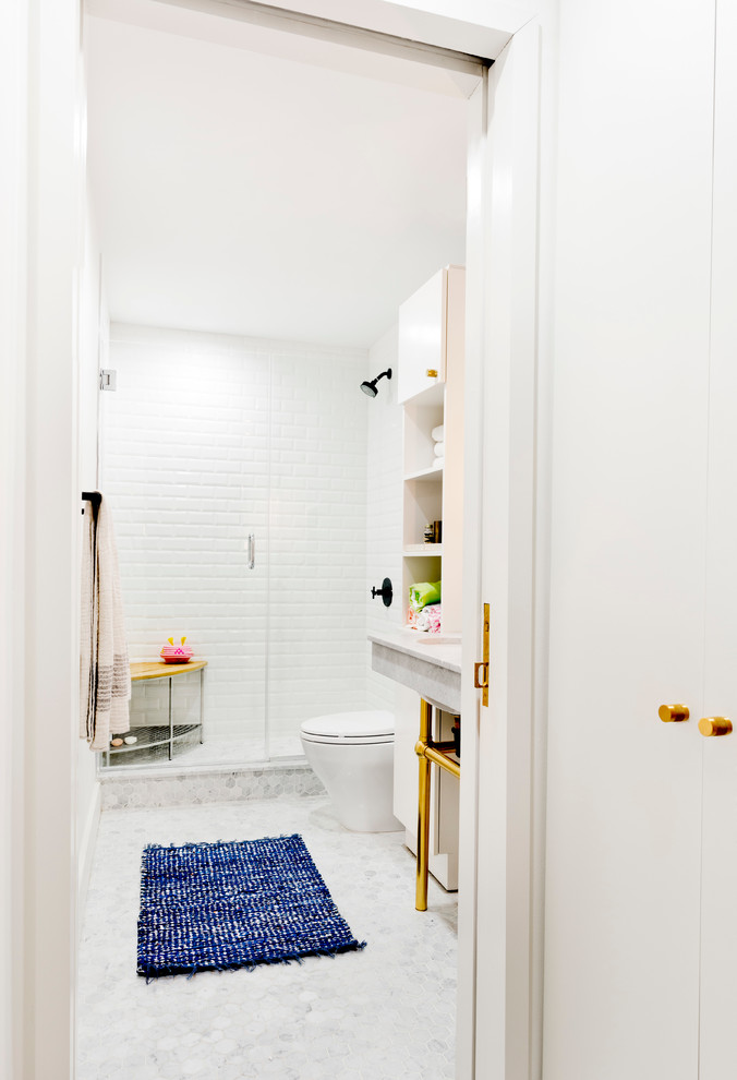 Medium sized traditional shower room bathroom in New York with open cabinets, white cabinets, an alcove shower, white tiles, metro tiles, white walls, mosaic tile flooring, a submerged sink, a one-piece toilet and marble worktops.