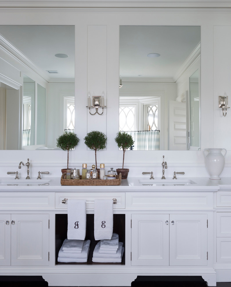 Foto di una stanza da bagno padronale chic con lavabo sottopiano, ante bianche, top in marmo, vasca freestanding, piastrelle bianche, pareti bianche e pavimento in legno massello medio