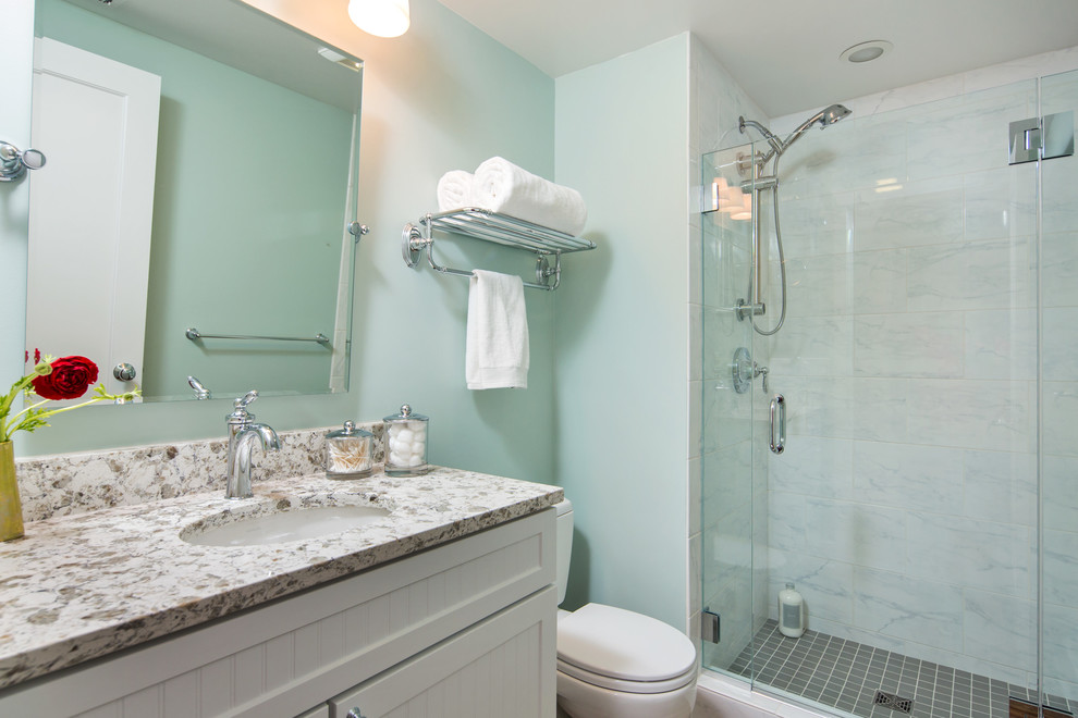 Small transitional 3/4 green tile gray floor alcove shower photo in Seattle with white walls, quartz countertops, a hinged shower door, multicolored countertops and a two-piece toilet