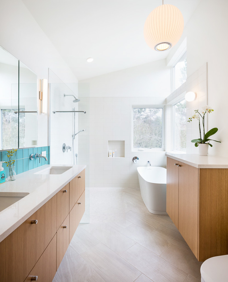 Inspiration pour une salle de bain design en bois brun avec un placard à porte plane, une baignoire indépendante, une douche à l'italienne, un carrelage bleu, un carrelage blanc, un mur blanc, un lavabo encastré, un sol beige et aucune cabine.