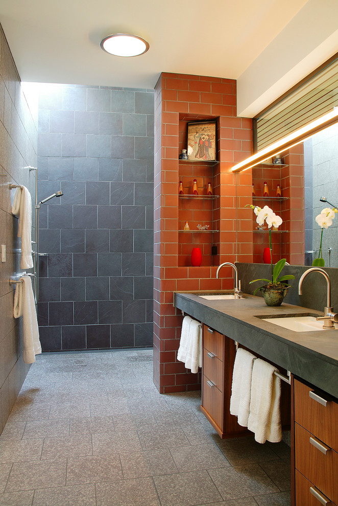 Idée de décoration pour une salle de bain design en bois brun avec un lavabo encastré, un placard à porte plane, un carrelage orange, une douche à l'italienne et un sol gris.