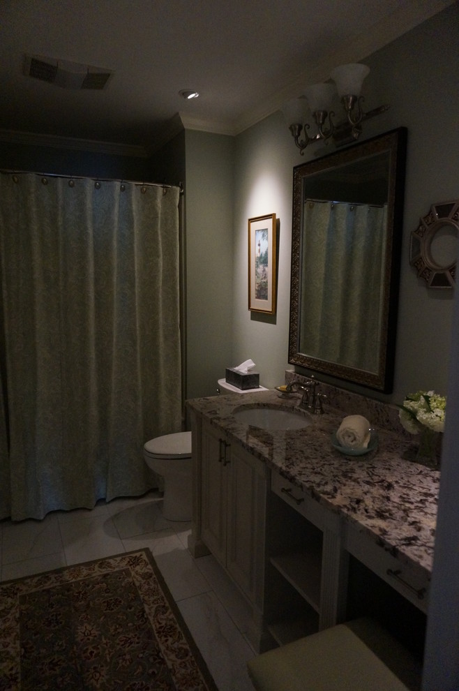 Ispirazione per una stanza da bagno tradizionale di medie dimensioni con lavabo sottopiano, ante verdi, top in granito, vasca/doccia, pareti verdi e pavimento in gres porcellanato