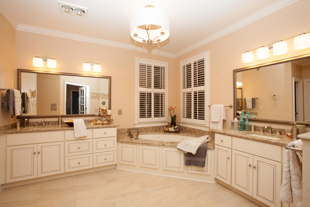 Klassisk inredning av ett stort en-suite badrum, med ett väggmonterat handfat, luckor med upphöjd panel, skåp i slitet trä, bänkskiva i kvartsit, ett undermonterat badkar, flerfärgad kakel och klinkergolv i porslin