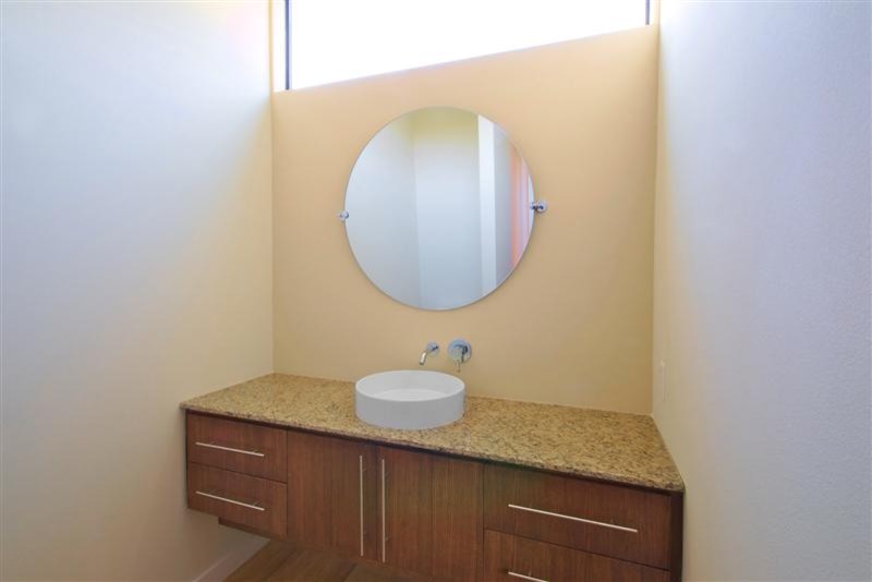 Ispirazione per una stanza da bagno con doccia moderna di medie dimensioni con ante lisce, ante in legno scuro, pareti beige, pavimento in legno massello medio, lavabo a bacinella e pavimento marrone