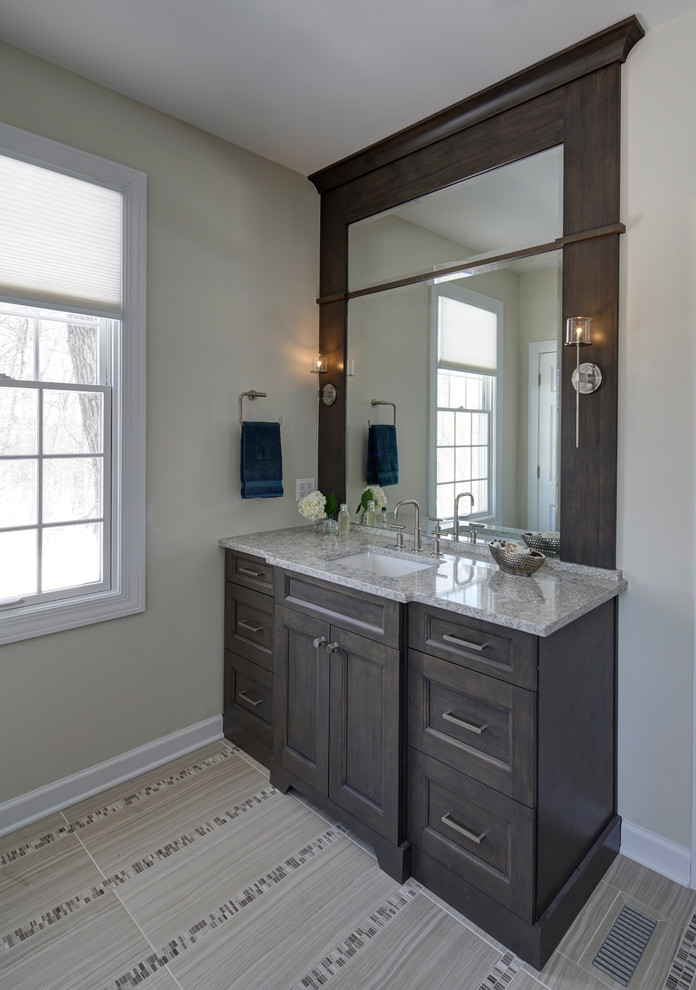 Example of a mid-sized transitional master gray tile and porcelain tile porcelain tile bathroom design in Chicago with shaker cabinets, dark wood cabinets, a two-piece toilet, gray walls, an undermount sink and quartz countertops