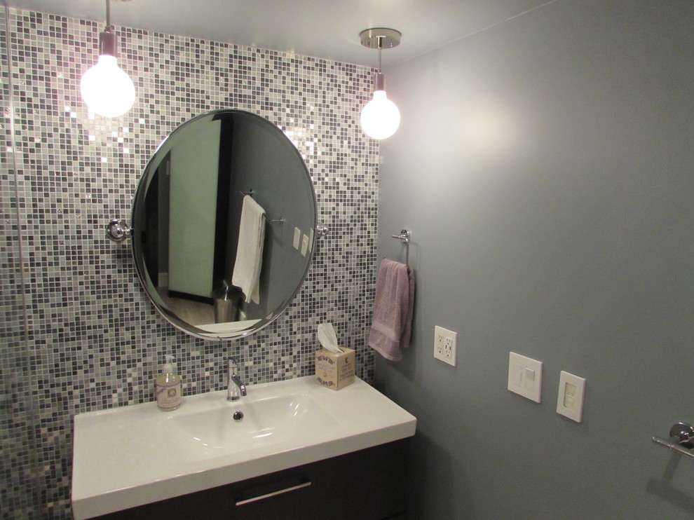 Exempel på ett litet modernt en-suite badrum, med kaklad bänkskiva, en hörndusch, en toalettstol med hel cisternkåpa, blå kakel, keramikplattor, vita väggar, mellanmörkt trägolv, släta luckor och ett integrerad handfat
