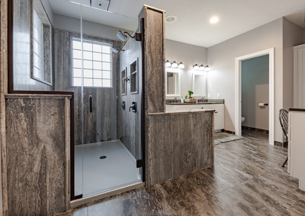 Expansive classic ensuite wet room bathroom in Omaha with raised-panel cabinets, white cabinets, a hot tub, a two-piece toilet, grey tiles, travertine tiles, grey walls, laminate floors, a submerged sink, wooden worktops, grey floors, a hinged door and grey worktops.