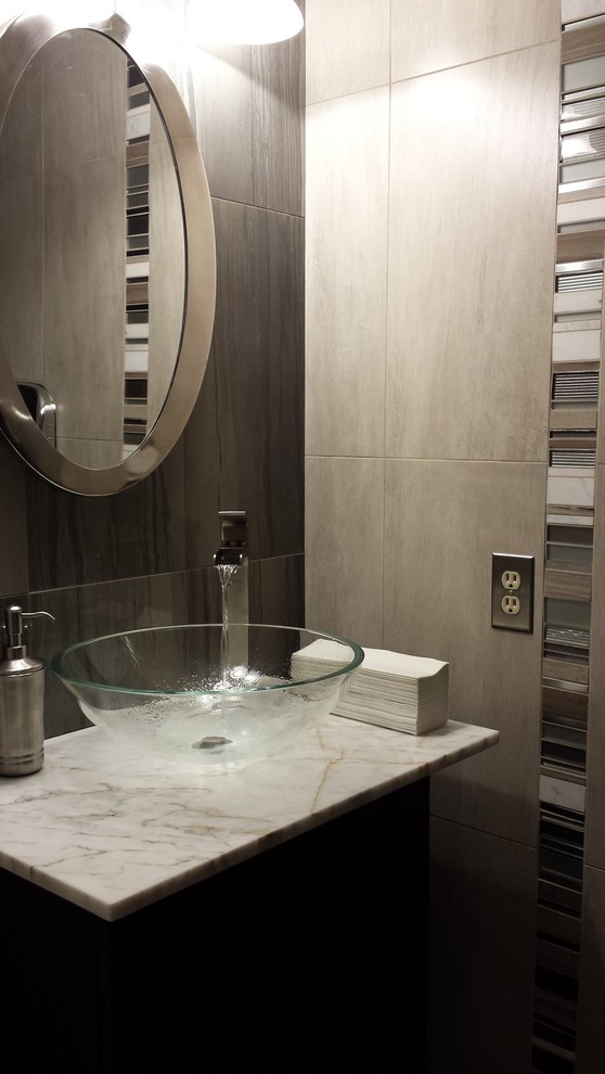 Photo of a small contemporary bathroom in Seattle with a vessel sink, flat-panel cabinets, dark wood cabinets, marble worktops, a two-piece toilet, grey tiles, porcelain tiles, grey walls and porcelain flooring.