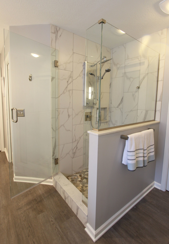 Inredning av ett klassiskt mellanstort en-suite badrum, med släta luckor, vita skåp, ett fristående badkar, en hörndusch, porslinskakel, grå väggar, laminatgolv, ett undermonterad handfat, bänkskiva i kvarts, brunt golv och dusch med gångjärnsdörr
