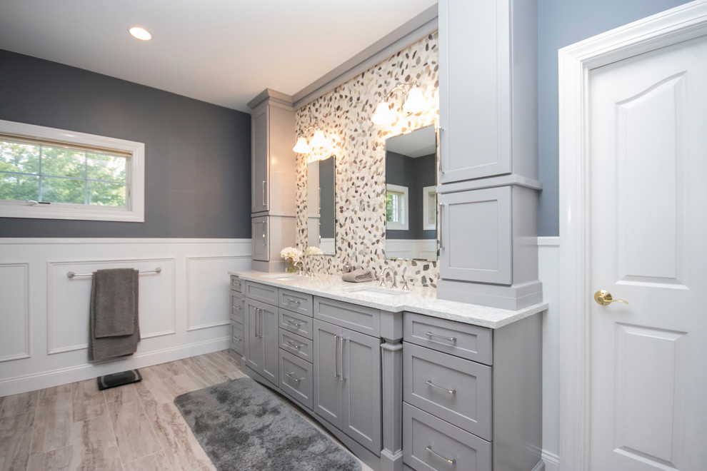 Example of a huge minimalist master multicolored tile and porcelain tile porcelain tile and beige floor corner shower design in Providence with recessed-panel cabinets, gray cabinets, a two-piece toilet, gray walls, an undermount sink, quartzite countertops and a hinged shower door