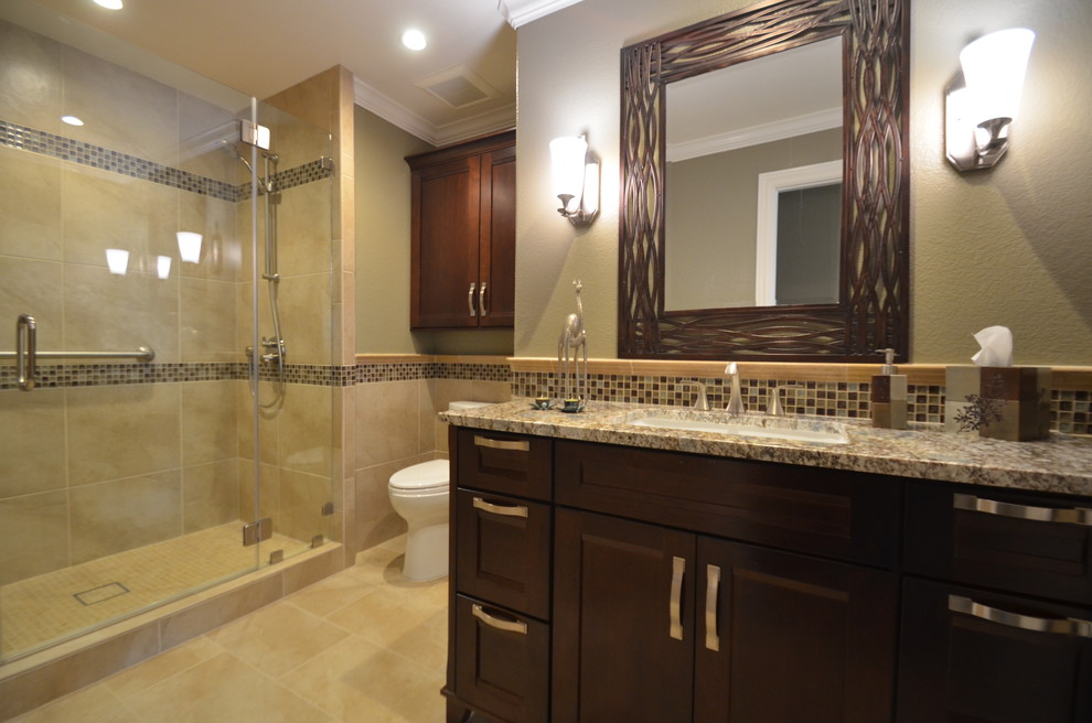 Inspiration for a timeless master beige tile and ceramic tile ceramic tile and beige floor bathroom remodel in San Francisco with recessed-panel cabinets, dark wood cabinets, beige walls, a two-piece toilet, an undermount sink, granite countertops and a hinged shower door