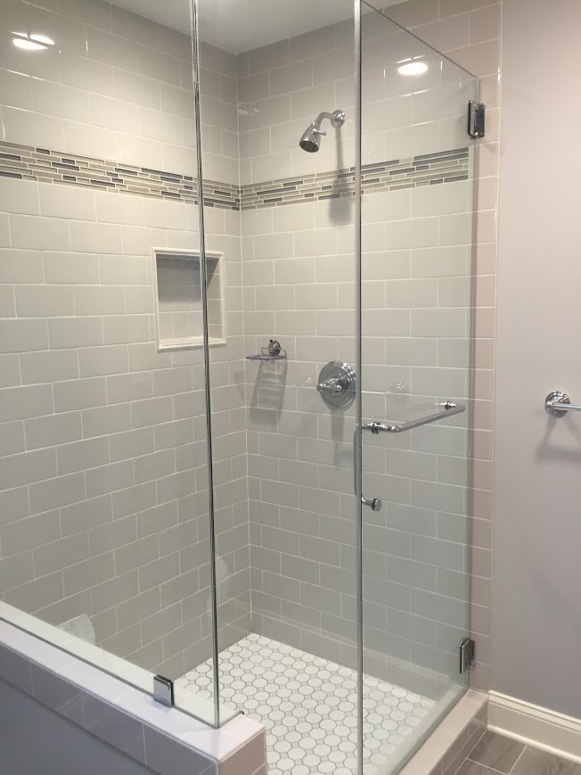 Cette image montre une salle de bain principale traditionnelle avec des portes de placard blanches, une baignoire indépendante, une douche d'angle, des carreaux de céramique, un mur gris, un sol en carrelage de porcelaine et un plan de toilette en granite.