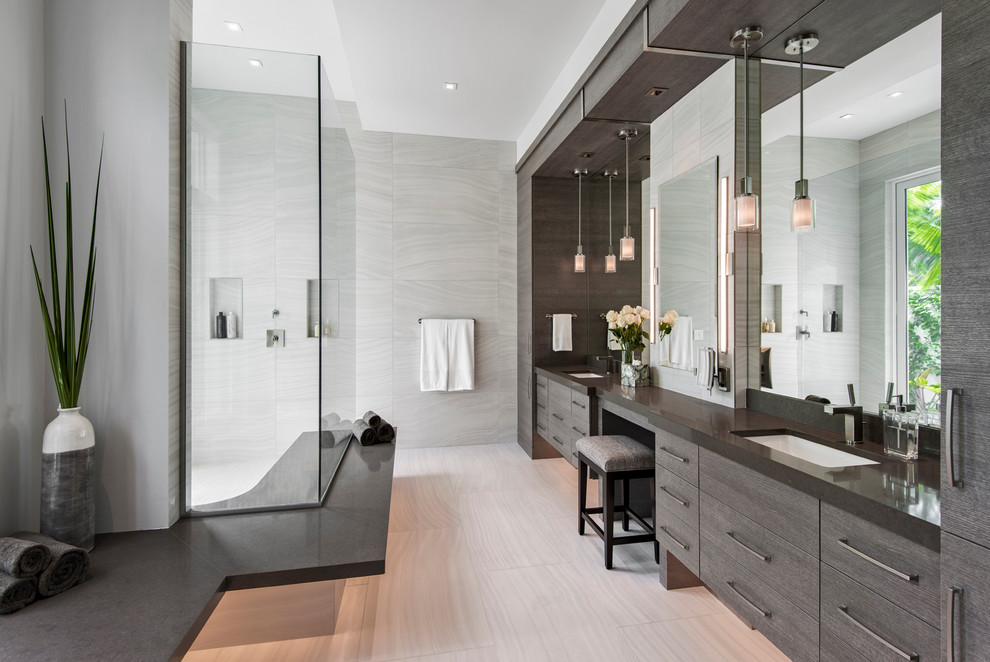 This is an example of a large contemporary ensuite bathroom in Miami with flat-panel cabinets, medium wood cabinets, porcelain tiles, grey walls, porcelain flooring, a submerged sink, solid surface worktops, a built-in shower, an open shower and grey worktops.
