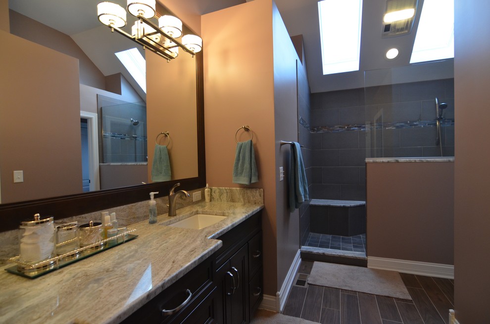 Exemple d'une grande salle de bain chic en bois foncé avec un lavabo encastré, un placard avec porte à panneau encastré, un plan de toilette en granite, une douche ouverte, WC séparés, un carrelage gris, des carreaux de porcelaine, un mur gris et un sol en carrelage de porcelaine.