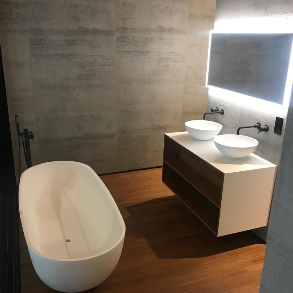 Inspiration for a mid-sized contemporary kids' travertine tile light wood floor, brown floor and double-sink freestanding bathtub remodel in Other with open cabinets, white cabinets, gray walls, a vessel sink, concrete countertops, white countertops and a floating vanity