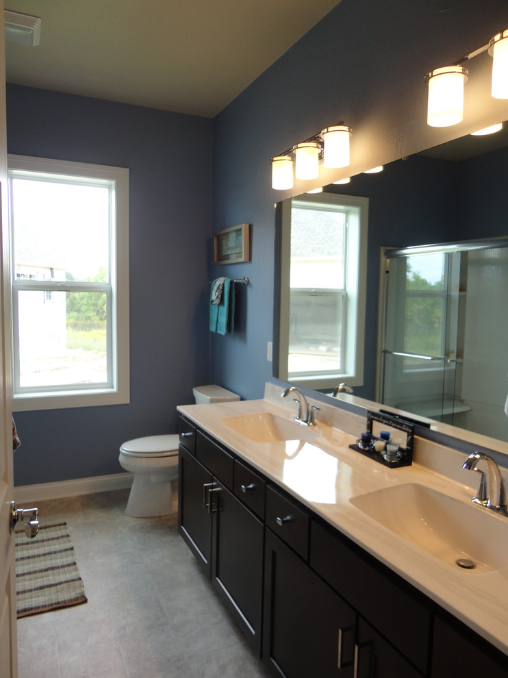 Cette photo montre une grande douche en alcôve chic en bois foncé pour enfant avec un lavabo intégré, un placard avec porte à panneau encastré, une baignoire posée, WC séparés, un mur bleu et un sol en vinyl.