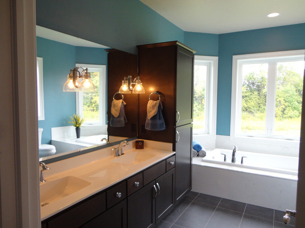 Пример оригинального дизайна: большая главная ванная комната в классическом стиле с монолитной раковиной, фасадами с утопленной филенкой, темными деревянными фасадами, накладной ванной, угловым душем, раздельным унитазом, черной плиткой, керамической плиткой, синими стенами и полом из керамической плитки