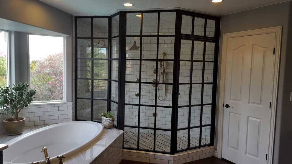Diseño de cuarto de baño principal actual de tamaño medio con bañera encastrada, ducha empotrada, baldosas y/o azulejos blancos, baldosas y/o azulejos de cerámica, paredes grises y suelo de madera oscura