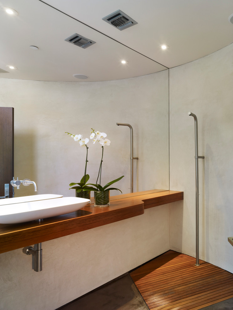 Foto på ett mellanstort funkis brun badrum med dusch, med ett fristående handfat, en öppen dusch, träbänkskiva, vita väggar och betonggolv