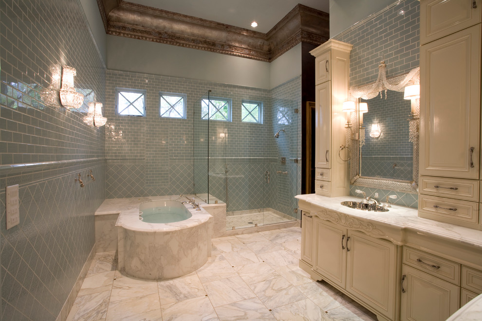 Inspiration pour une grande salle de bain principale méditerranéenne avec un lavabo encastré, un placard en trompe-l'oeil, des portes de placard beiges, un plan de toilette en marbre, une baignoire encastrée, un combiné douche/baignoire, WC à poser, un carrelage bleu, des carreaux de céramique, un mur bleu et un sol en marbre.