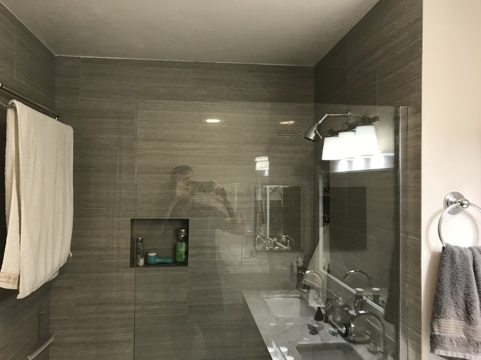 Mid-sized minimalist master gray tile and porcelain tile porcelain tile and brown floor doorless shower photo in Los Angeles with shaker cabinets, white cabinets, a two-piece toilet, white walls, an undermount sink, marble countertops, a hinged shower door and gray countertops