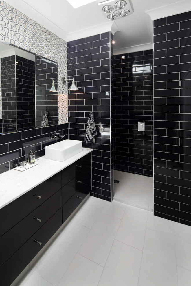 Источник вдохновения для домашнего уюта: большая ванная комната в стиле модернизм с черными фасадами, ванной на ножках, душем в нише, унитазом-моноблоком, черной плиткой, плиткой кабанчик, черными стенами, полом из керамогранита, душевой кабиной, настольной раковиной, мраморной столешницей, серым полом и открытым душем