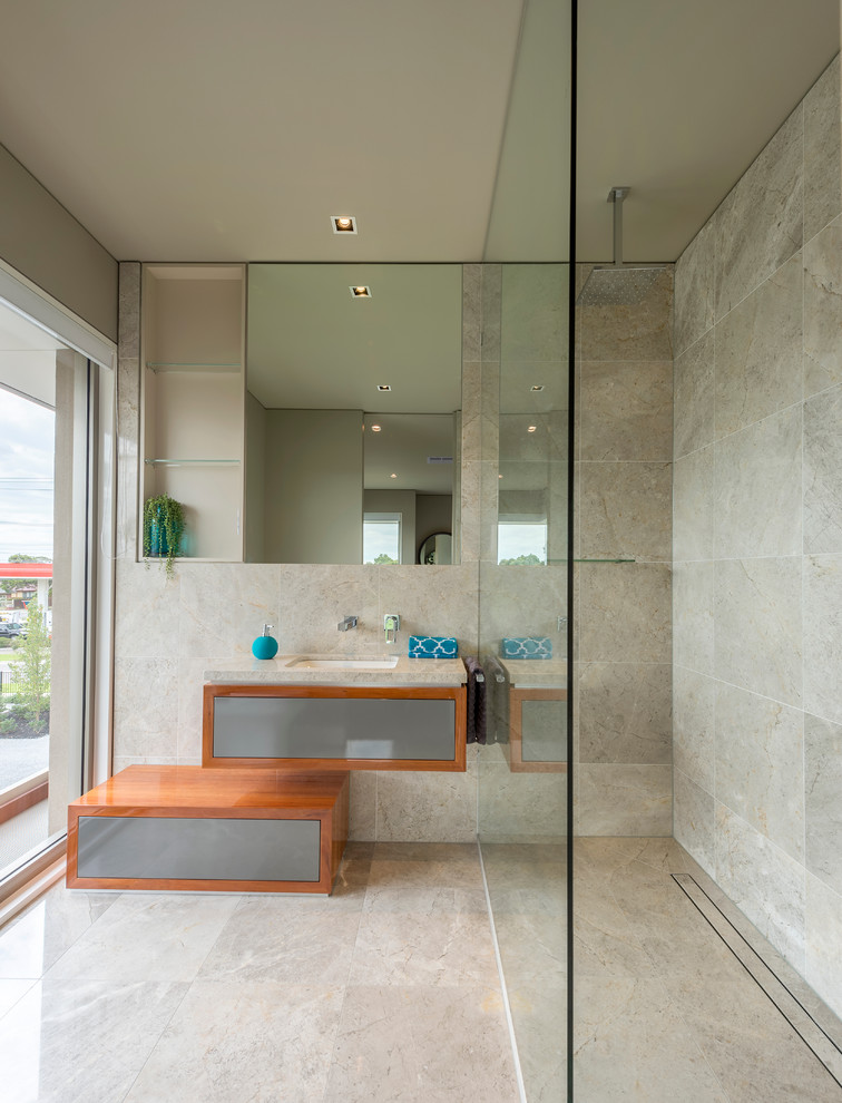Imagen de cuarto de baño moderno con armarios tipo vitrina, puertas de armario de madera clara, baldosas y/o azulejos de piedra y encimera de mármol