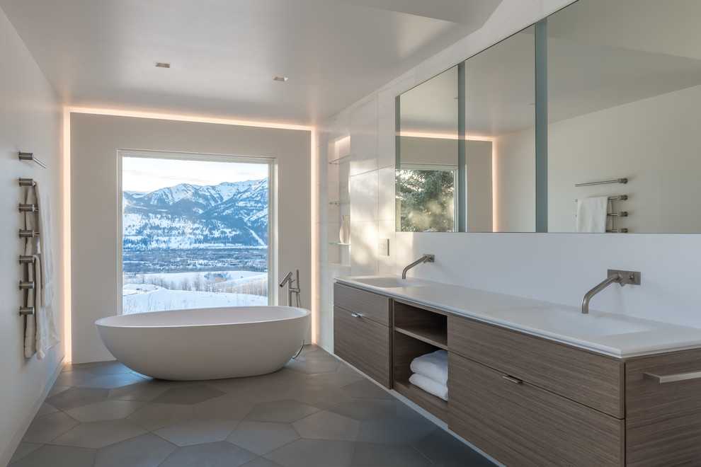 Trendy master freestanding bathtub photo in Other with flat-panel cabinets, medium tone wood cabinets, white walls and an integrated sink