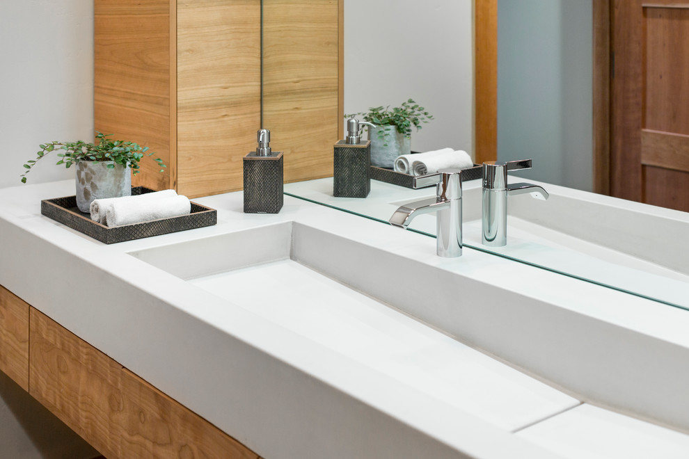 Large contemporary ensuite bathroom in Other with flat-panel cabinets, medium wood cabinets, a walk-in shower, white tiles, white walls, a trough sink and solid surface worktops.