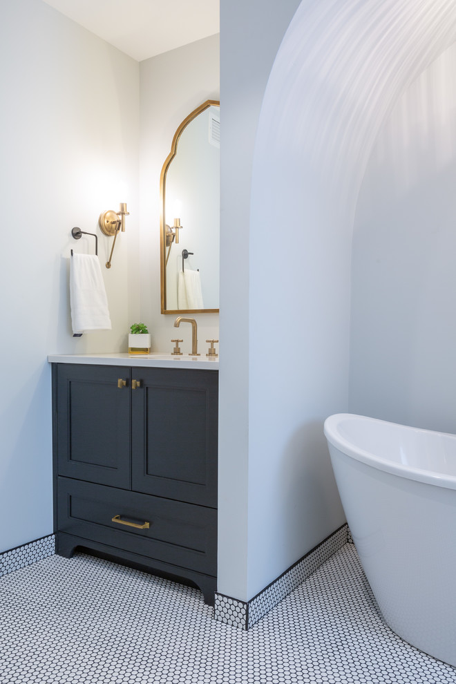 Пример оригинального дизайна: главная ванная комната среднего размера в стиле модернизм с фасадами в стиле шейкер, серыми фасадами, отдельно стоящей ванной, белыми стенами, монолитной раковиной, белым полом и белой столешницей