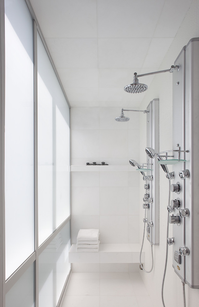 Cette image montre une salle de bain minimaliste avec une douche double et un banc de douche.