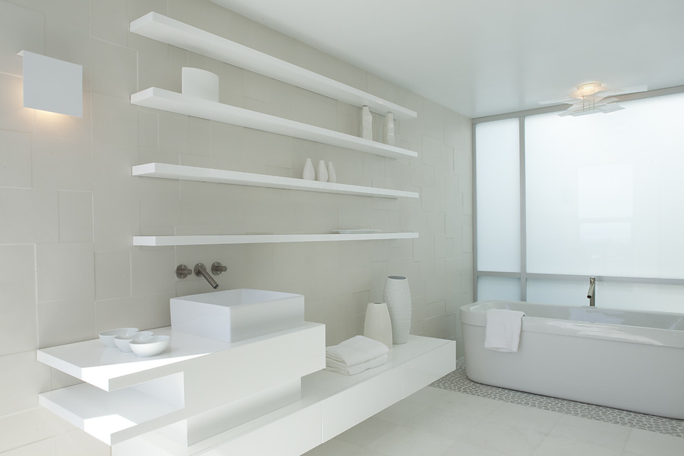 Freestanding bathtub - modern pebble tile floor freestanding bathtub idea in San Francisco with a vessel sink