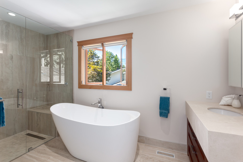Inspiration for a mid-sized transitional master white tile and limestone tile porcelain tile and beige floor bathroom remodel in Vancouver with shaker cabinets, dark wood cabinets, a one-piece toilet, white walls, an undermount sink, quartzite countertops and a hinged shower door