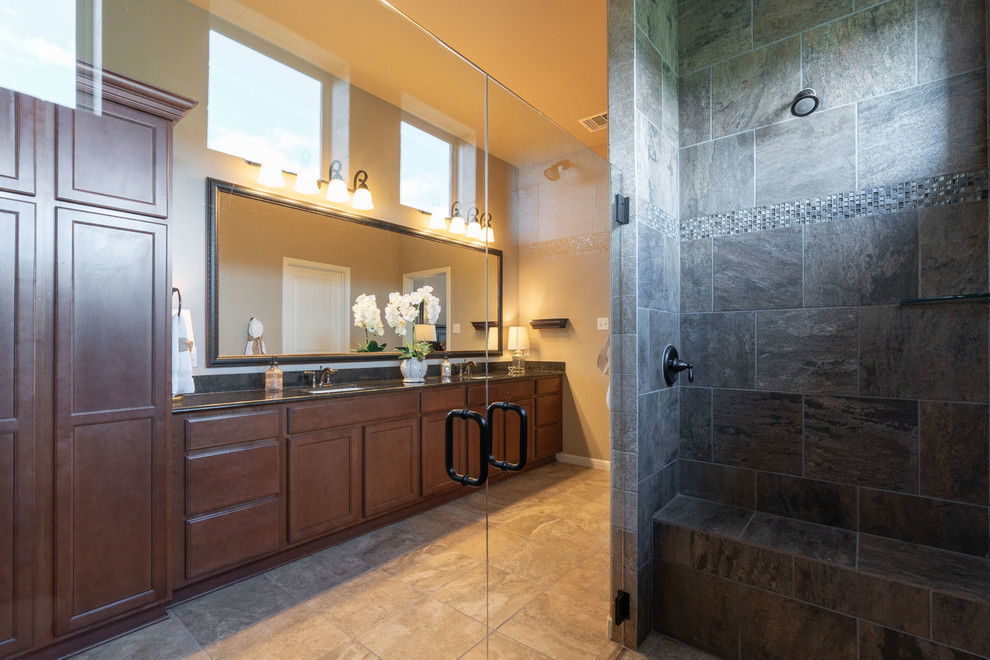 Example of a mid-sized transitional master brown tile and ceramic tile ceramic tile and brown floor double shower design in Austin with recessed-panel cabinets, medium tone wood cabinets, a two-piece toilet, beige walls, an undermount sink, granite countertops, a hinged shower door and black countertops