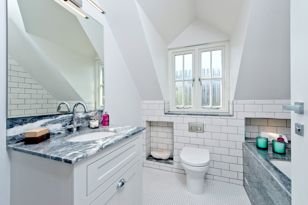 Photo of a medium sized classic family bathroom in London with freestanding cabinets, beige cabinets, a built-in bath, a shower/bath combination, a wall mounted toilet, ceramic flooring, a built-in sink, marble worktops, white floors, yellow tiles and porcelain tiles.