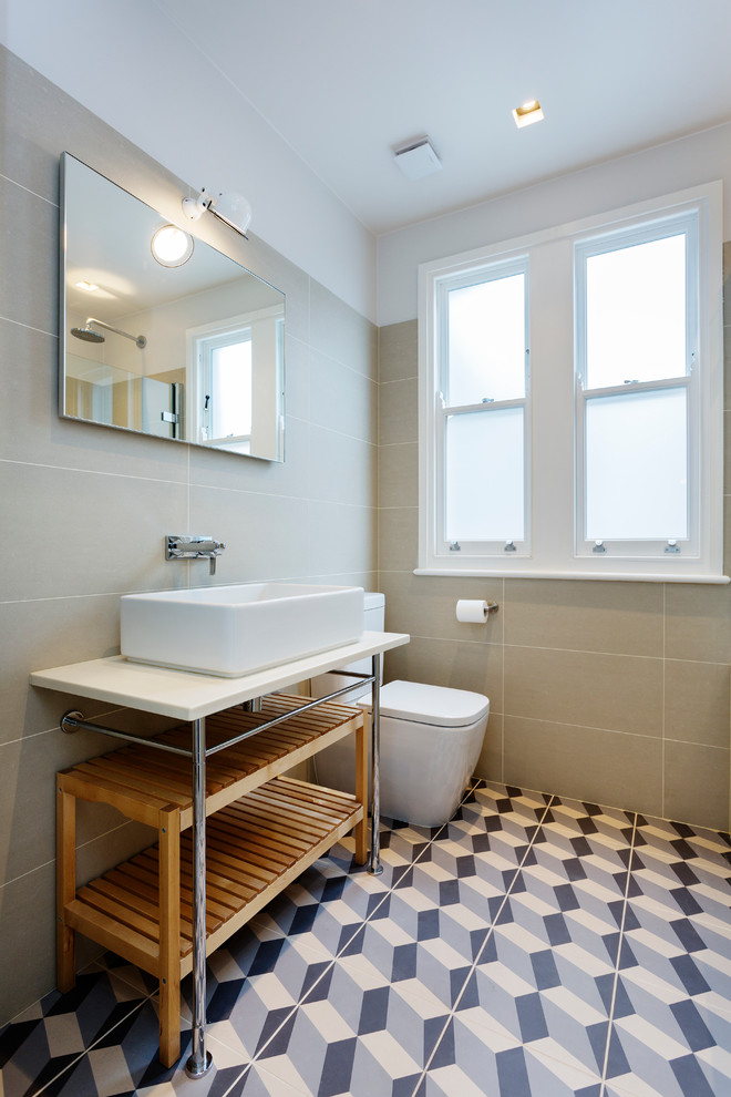 Photo of a scandinavian bathroom in London with a wall mounted toilet and a vessel sink.