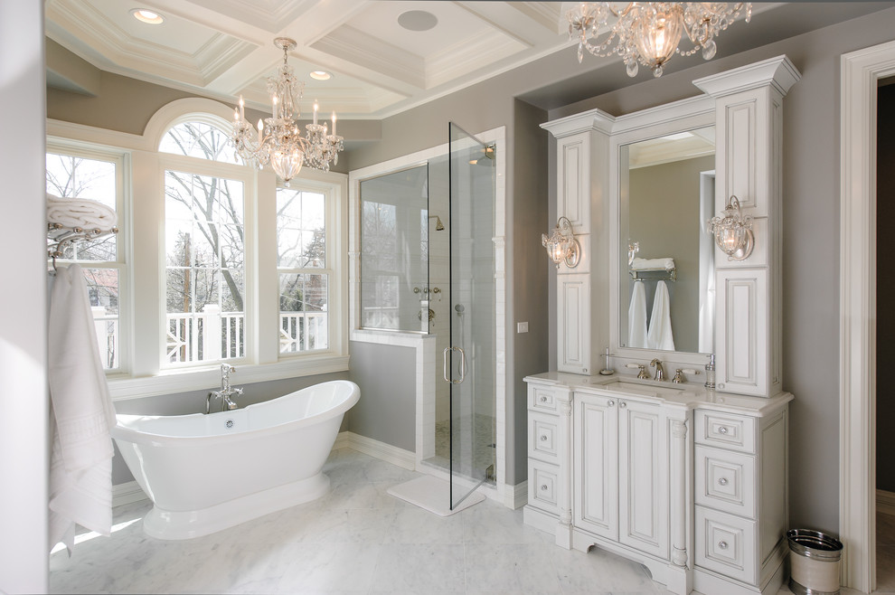 Пример оригинального дизайна: ванная комната в классическом стиле с врезной раковиной, фасадами с выступающей филенкой, белыми фасадами, отдельно стоящей ванной, душем в нише, белой плиткой и серыми стенами