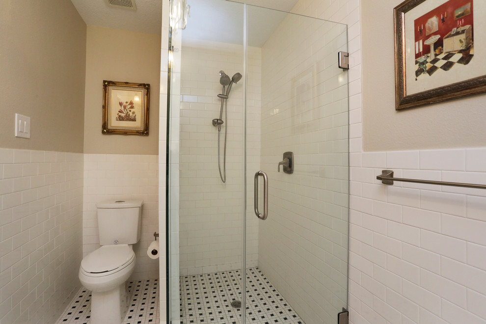 Photo of a small classic shower room bathroom in Houston with a pedestal sink, a corner shower, a one-piece toilet, white tiles, metro tiles, beige walls and mosaic tile flooring.