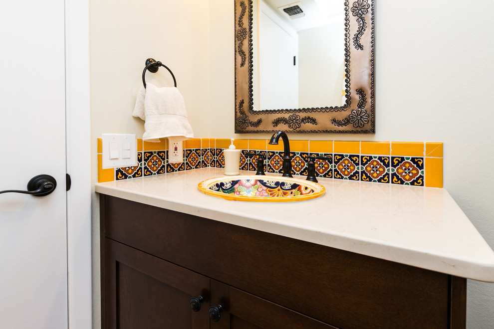Cette image montre une petite salle d'eau bohème avec un placard à porte shaker, des portes de placard marrons, un carrelage noir et blanc, un carrelage jaune, des carreaux de porcelaine, un mur blanc, tomettes au sol, un lavabo posé et un plan de toilette en marbre.