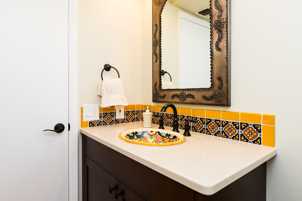 Cette photo montre une petite salle de bain sud-ouest américain en bois foncé avec un placard à porte shaker, un carrelage multicolore, des carreaux de céramique, un mur beige, un lavabo posé, un plan de toilette en quartz modifié et un sol en carrelage de céramique.