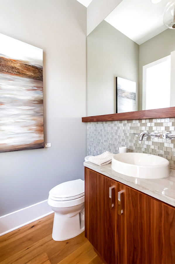 Idéer för ett mellanstort modernt badrum med dusch, med granitbänkskiva, ett fristående badkar, en hörndusch, släta luckor, skåp i mellenmörkt trä, glaskakel, grå väggar, mellanmörkt trägolv, ett fristående handfat och brunt golv
