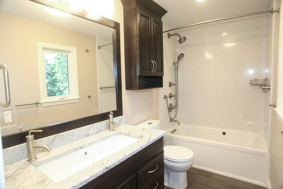 Exemple d'une salle de bain chic de taille moyenne avec un placard avec porte à panneau surélevé, des portes de placard noires, une baignoire en alcôve, un combiné douche/baignoire, un carrelage noir et blanc, des dalles de pierre, un mur beige, une grande vasque et un plan de toilette en granite.