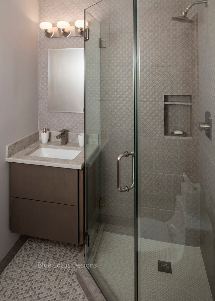 Inspiration for a mid-sized transitional kids' gray tile and porcelain tile porcelain tile and multicolored floor corner shower remodel in Philadelphia with flat-panel cabinets, medium tone wood cabinets, a one-piece toilet, gray walls, an undermount sink, quartz countertops and a hinged shower door