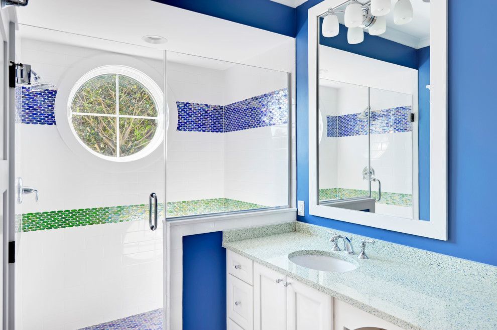 Foto de cuarto de baño costero con armarios con paneles lisos, puertas de armario blancas y paredes azules