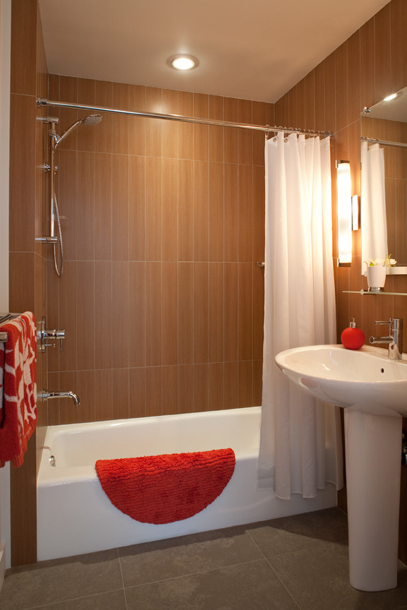 Esempio di una stanza da bagno minimalista con lavabo a colonna, vasca ad alcova, piastrelle marroni e pavimento in gres porcellanato