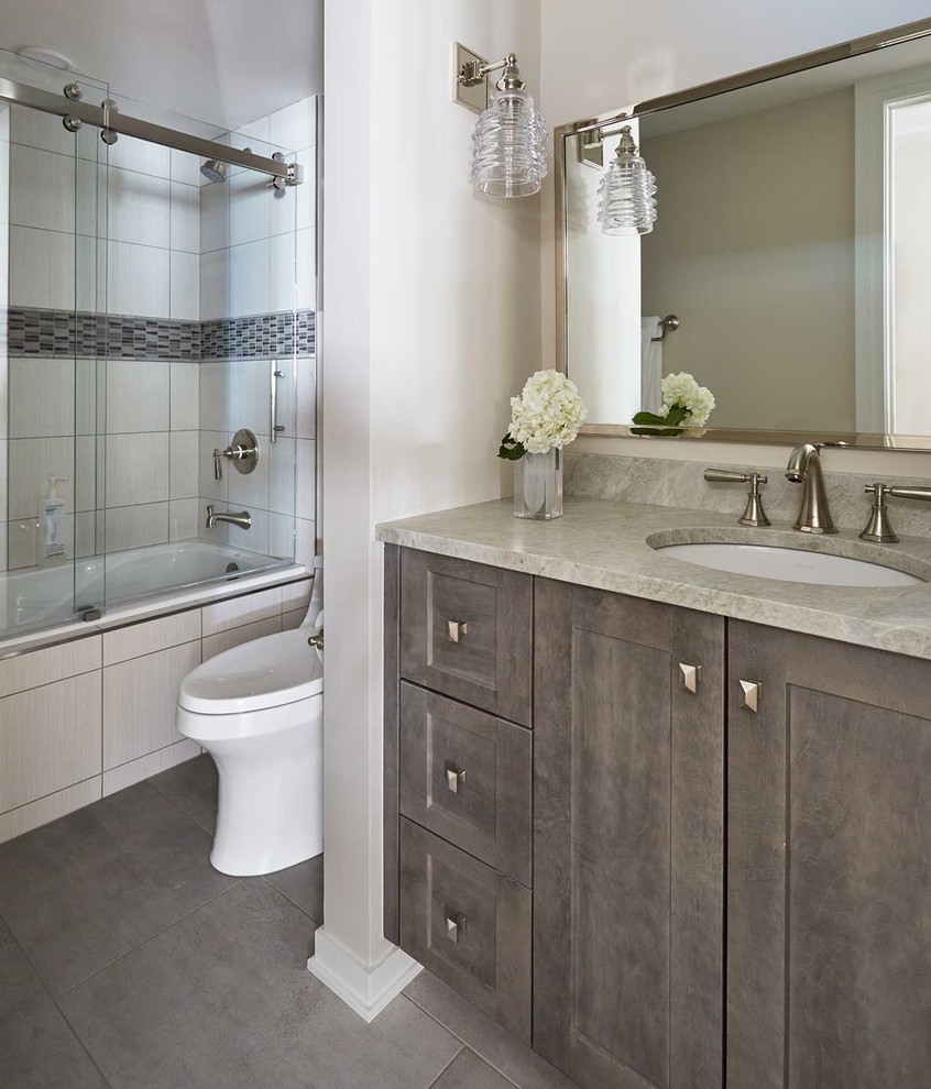 Exempel på ett mellanstort modernt grå grått en-suite badrum, med luckor med infälld panel, grå skåp, ett badkar i en alkov, en dusch i en alkov, en toalettstol med hel cisternkåpa, grå väggar, klinkergolv i keramik, ett undermonterad handfat, bänkskiva i kvartsit, brunt golv och dusch med skjutdörr